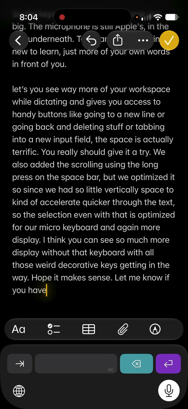 Notes mid-dictation: a long paragraph filling most of the screen, the Speaking Of keys underneath, and Apple's microphone lit in the row below.